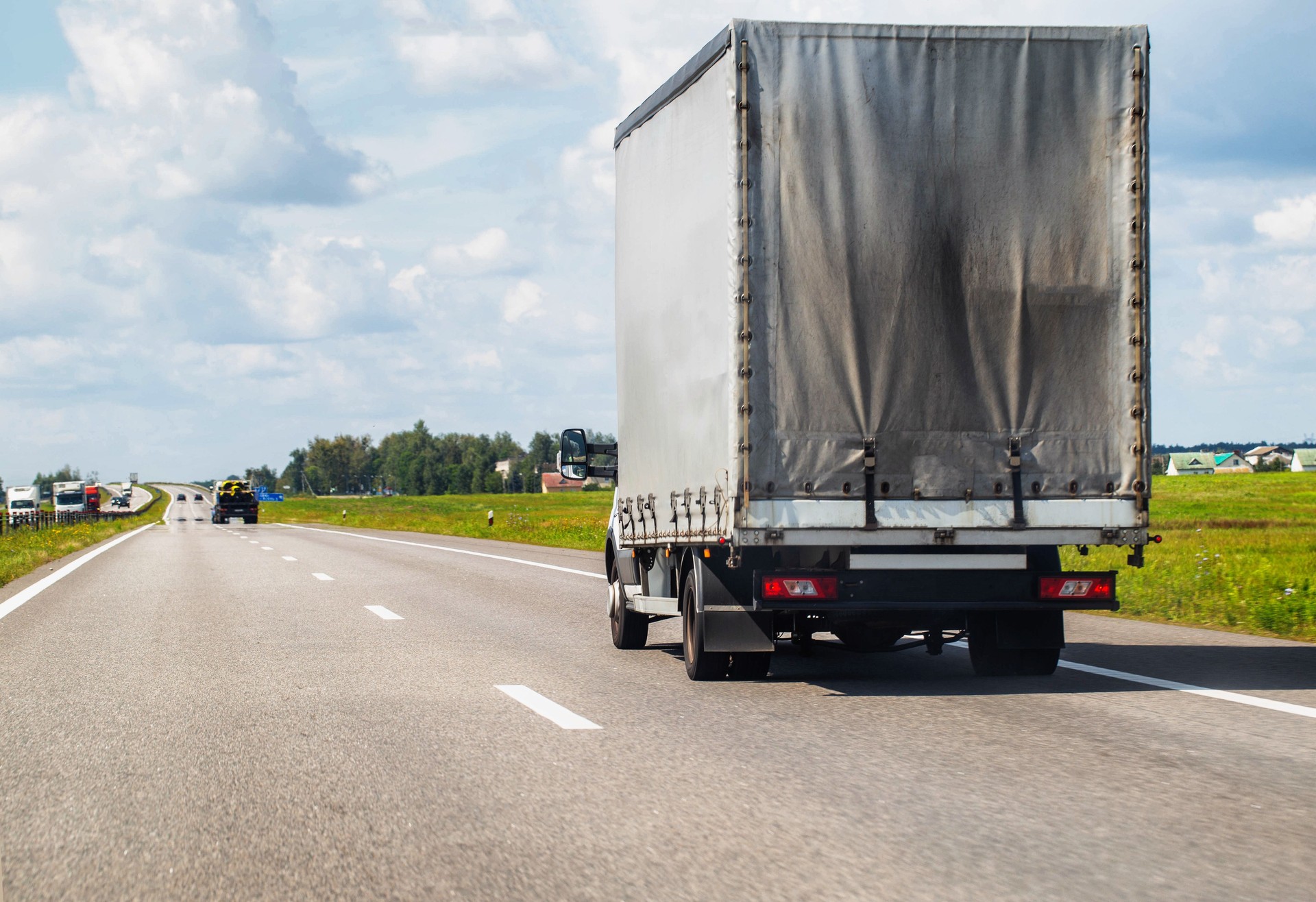 Specialized trucks with a carrying capacity of up to 5 tons transport cargo along the highway in the summer, industry. Copy space for text
